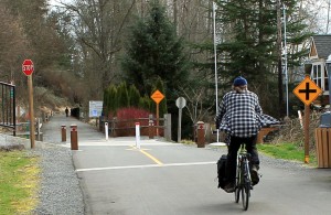 A cyclist heads from paved to gravel section of East Lake Sammamish Trail.