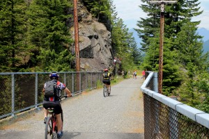Cyclists pass rock climbers on John Wayne Pioneer Trail